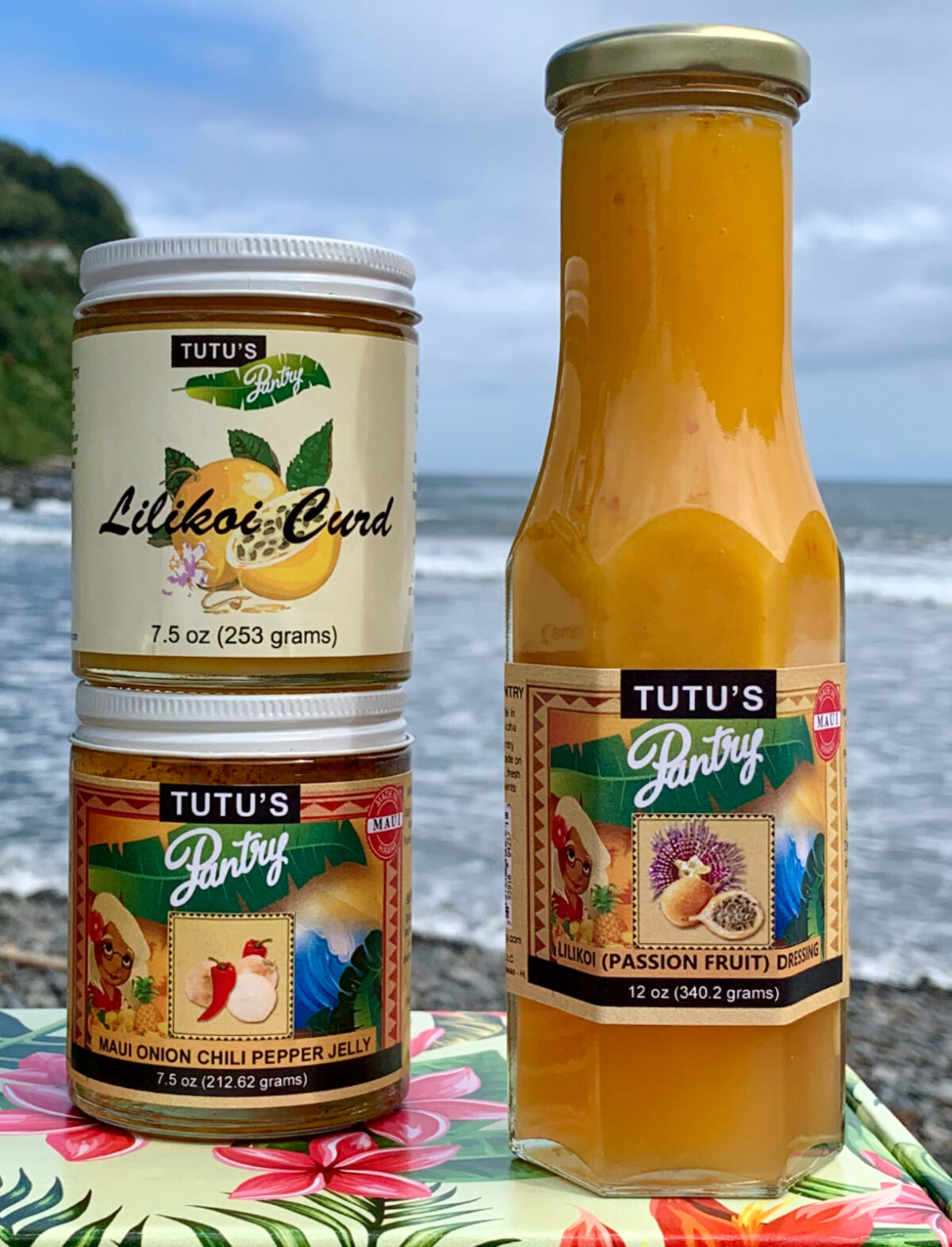 Tutu's Pantry lilikoi passion fruit jelly, butter, and syrup displayed together with a bottle of Maui Onion Chili Pepper Jelly